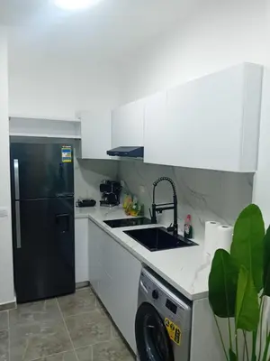 a kitchen with a black refrigerator and a dishwasher at Aqua Infinity D306 in Hurghada