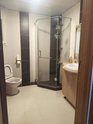 a bathroom with a shower and a toilet and a sink at Royal Beach Resort in Hurghada