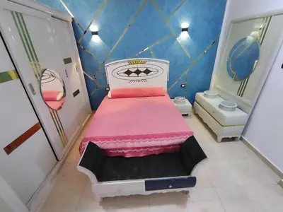 a small bedroom with a pink bed and a bathroom at SAMA HOUSE Cozy Mountain Hideaway in Luxor in ‘Ezbet Abu Ḥabashi
