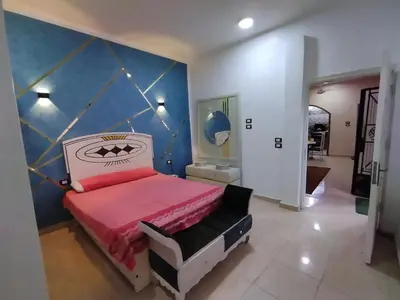 a bedroom with a bed and a blue wall at SAMA HOUSE Cozy Mountain Hideaway in Luxor in ‘Ezbet Abu Ḥabashi