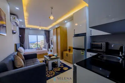 a kitchen and living room with a couch and a microwave at Arena Beach Resort in Hurghada