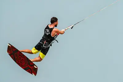 a man is in the air on a surfboard at Arena Beach Resort in Hurghada