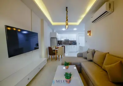 a living room with a couch and a large tv at Arena Beach Resort in Hurghada