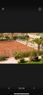 two people playing tennis on a tennis court at Timeshare for rent at sunny days family resort in Hurghada