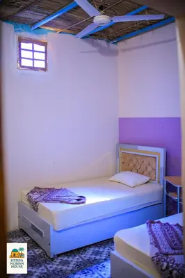 a bedroom with two beds and a window at Heissa Nubian Hostel in Aswân Reservoir Colony