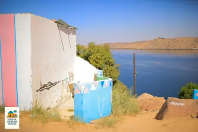 a building on the side of a body of water at Heissa Nubian Hostel in Aswân Reservoir Colony