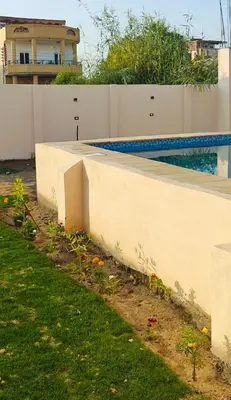 a white retaining wall next to a swimming pool at Morsy Palace in Luxor