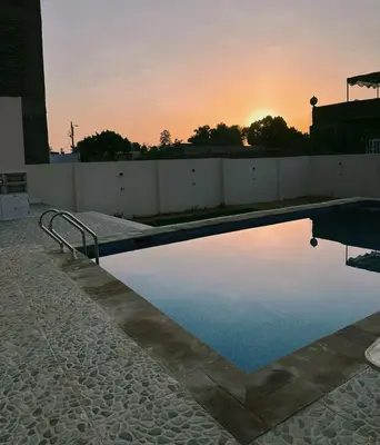 a swimming pool with the sunset in the background at Morsy Palace in Luxor