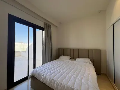 a bedroom with a bed and a large window at Stylish 1BR Retreat – Ancient Sands El Gouna in Hurghada