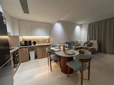a kitchen and a living room with a table and chairs at Stylish 1BR Retreat – Ancient Sands El Gouna in Hurghada