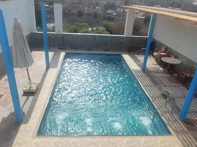 a swimming pool on the balcony of a building at Ashria gest house in Jazīrat Salūjah