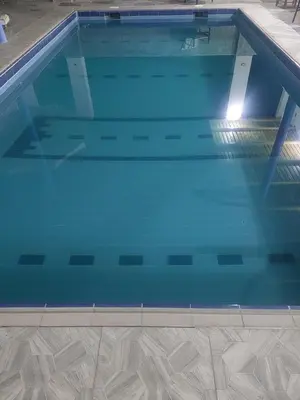 a large swimming pool with blue water at Ashria gest house in Jazīrat Salūjah