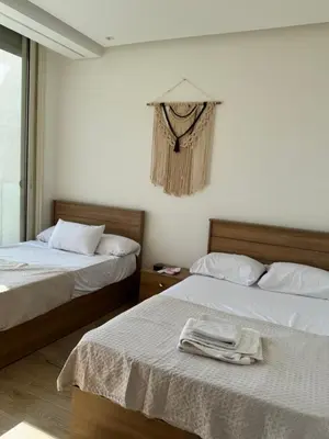 a bedroom with two beds with towels on them at ELGOUNA Maraya duplex pool view in Hurghada