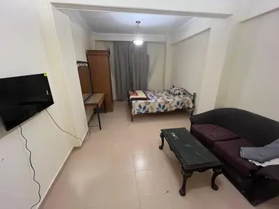 a small living room with a couch and a bed at Cozy Apartment, on Sheraton Road Near Metro Market in Hurghada