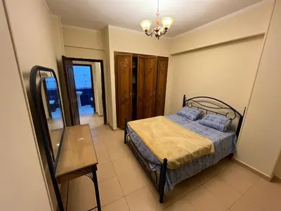 a bedroom with a bed and a table at Cozy Apartment, on Sheraton Road Near Metro Market in Hurghada