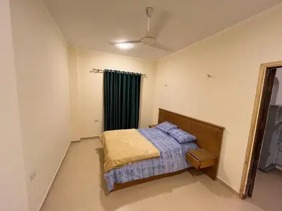 a bedroom with a bed and a green curtain at Cozy Apartment, on Sheraton Road Near Metro Market in Hurghada