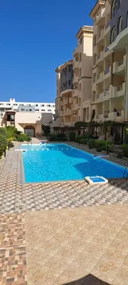 a swimming pool in front of a building at Florenza Resort - Roboost - Hurghada in Hurghada