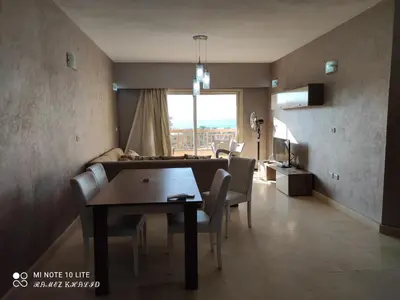 a living room with a dining room table and a couch at Relaxing Apartment in Hurghada