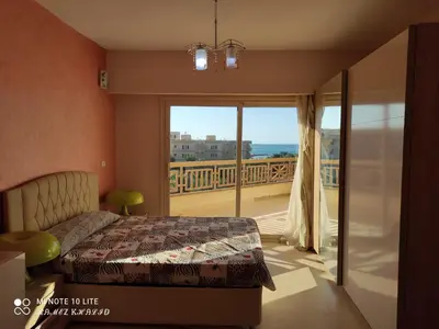 a bedroom with a bed and a balcony with a view at Relaxing Apartment in Hurghada