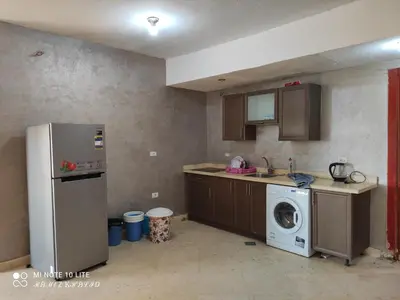 a kitchen with a refrigerator and a washing machine at Relaxing Apartment in Hurghada