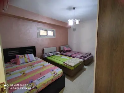 a bedroom with two beds and a window at Relaxing Apartment in Hurghada