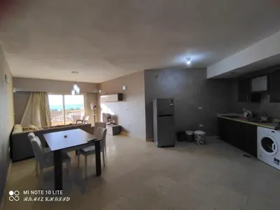 a kitchen and living room with a table and a dining room at Relaxing Apartment in Hurghada