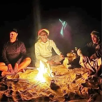 a group of people sitting around a fire at Katadool Boat in Aswan