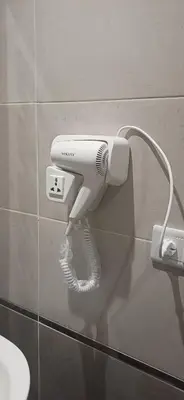 a hair dryer hanging on a wall in a bathroom at Luxury Studio Pool & Free Private Beach, Close to Airport in Hurghada