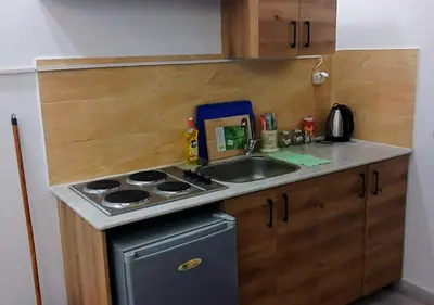 a small kitchen with a sink and a stove at Cozy 1BR Pool View Apartment Steps from the Beach in Hurghada
