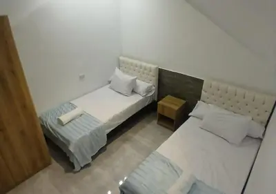 a small bedroom with two beds and a table at Cozy 1BR Pool View Apartment Steps from the Beach in Hurghada