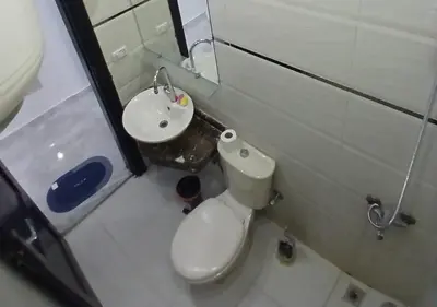 a small bathroom with a toilet and a sink at Cozy 1BR Pool View Apartment Steps from the Beach in Hurghada
