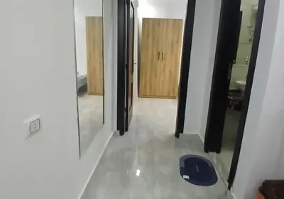 a view of a hallway with a mirror and a door at Cozy 1BR Pool View Apartment Steps from the Beach in Hurghada