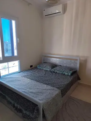 a large bed in a white room with a window at Paradise Vibe Apartment in Hurghada