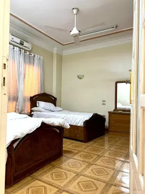 a bedroom with two beds and a large mirror at Moon shadow in Luxor