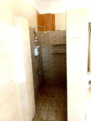 a shower in a bathroom with a wooden floor at Moon shadow in Luxor