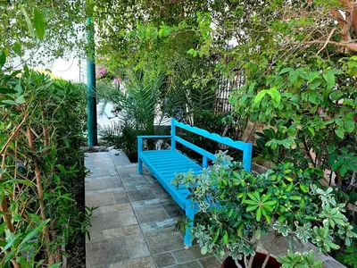 a blue bench sitting on a stone walk way at The White Lions Villa in Hurghada