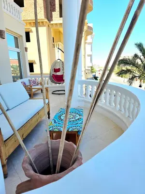 a porch with a couch and a swing at The White Lions Villa in Hurghada