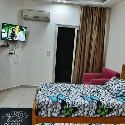 a room with a bed and a tv on the wall at كذا بلانكا بيتش417 in Hurghada