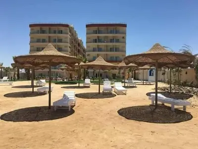 a group of chairs and umbrellas on a beach at كذا بلانكا بيتش417 in Hurghada