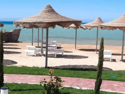 a beach with chairs and umbrellas and the ocean at كذا بلانكا بيتش417 in Hurghada