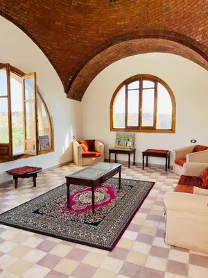 a living room with a table on a rug at ايـو كـاتو in Jazīrat ‘Awwāḑ