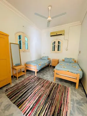 a room with two beds and a rug at ايـو كـاتو in Jazīrat ‘Awwāḑ