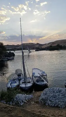 three boats docked on the shore of a body of water at Esmerada in Aswan