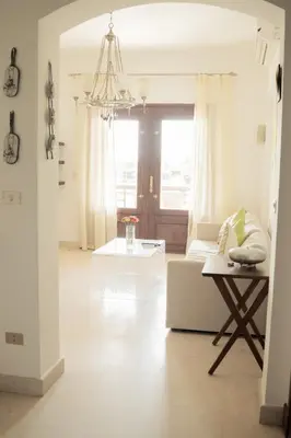 a living room with a white couch and a table at Nayah Stays, Cozy lagoons terrace one ensuite Apt in Hurghada