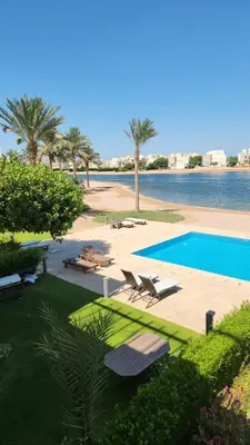 a swimming pool next to a body of water at Nayah Stays, Joubal Lagoons Terrace in Hurghada