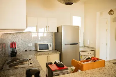 a kitchen with a refrigerator and a microwave at Nayah Stays, Joubal Lagoons Terrace in Hurghada