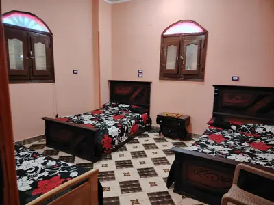 a room with two beds and two windows at Venti house in Aswan