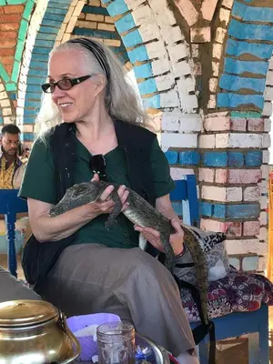 a woman holding a snake in her lap at Dahabiya Nile Cruise in Luxor