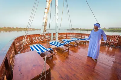 a woman standing on the deck of a boat at Dahabiya Nile Cruise in Luxor