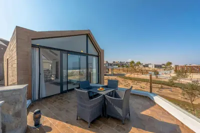 a patio with a table and chairs on a balcony at Luxury Stays in Wadi Jebal Soma Bay in Hurghada